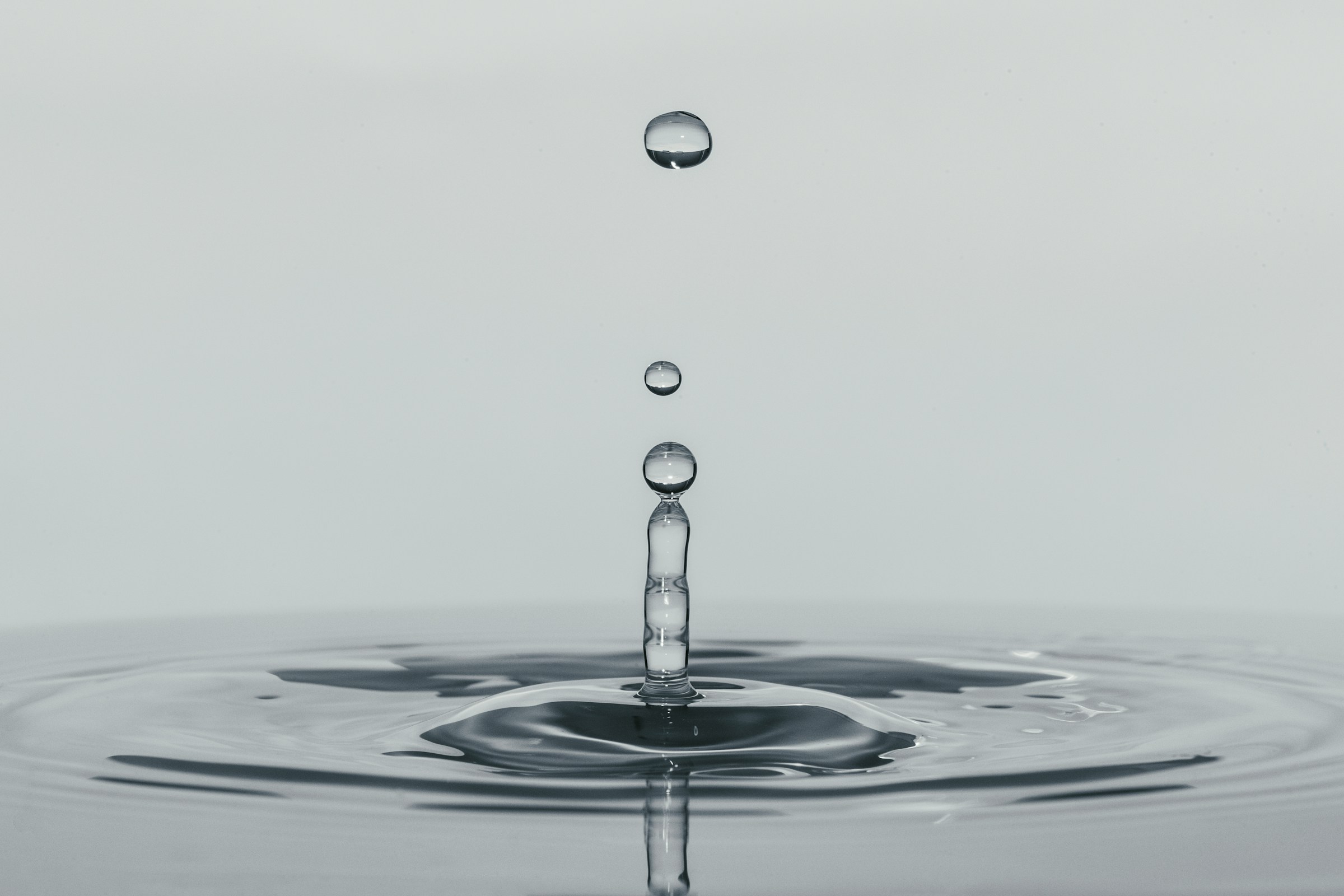 A water droplet above a still surface