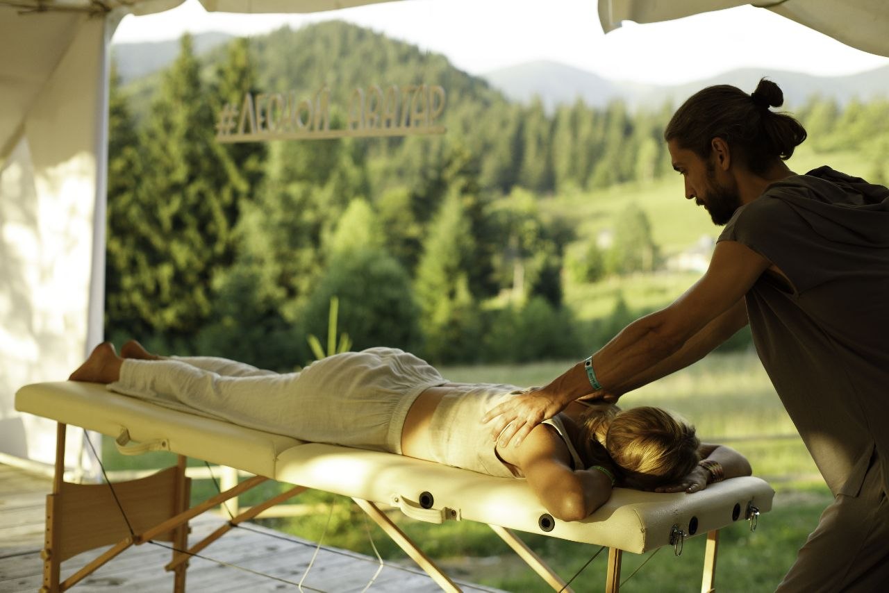 Practitioner working on a client's shoulders on a massage table